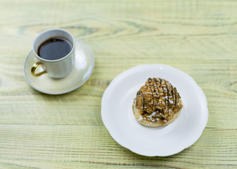Coffee in a retro cup and cake on a wooden background.