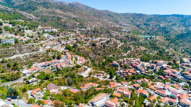 Aerial view of Kyperounda village on Madari, Troodos mountain, Limassol, Cyprus. Bird eye view of traditional ceramic tiled roof houses, countryside, valley and church from above.