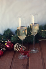 two New Year's glasses with champagne wine on a wooden table and a white background