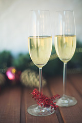 two New Year's glasses with champagne wine on a wooden table and a white background