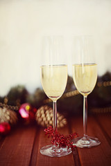 two New Year's glasses with champagne wine on a wooden table and a white background