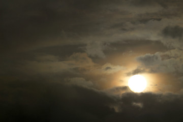 A sun similar to the full moon seen from the cloudy sky