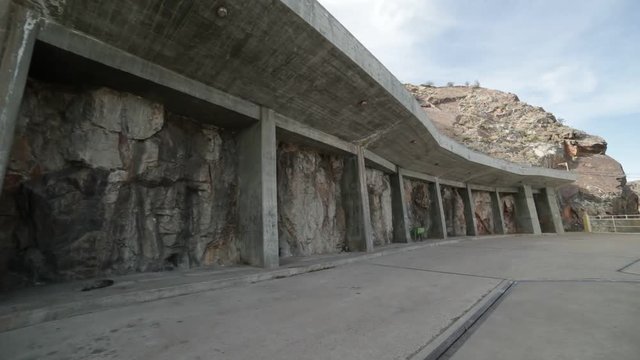 Brutalist, modern concrete structures supporting rock wall. Parking lot for Agua de Toro Dam. San Rafael, Mendoza, Argentina.