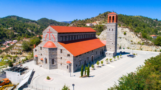 Aerial view of Agios Arsenios church, Kyperounda village, Limassol, Cyprus. Traditional landmark christian greek orthodox, ceramic tiled roof, stone bell tower architecture in Kyperounta from above