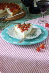 Tart, pie or cheesecake with cottage cheese and tomatoes, served with red wine on a wooden background.