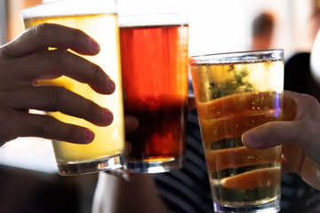 Glasses of different beers touching together. Friendship and holiday concept