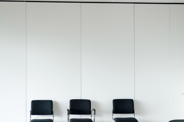 Chairs in waiting room white walls, front view