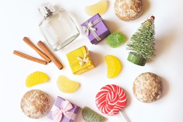 Flat lay winter holidays presents/ Christmas tree, perfume bottle, gift boxes, sweet candies and gingerbread