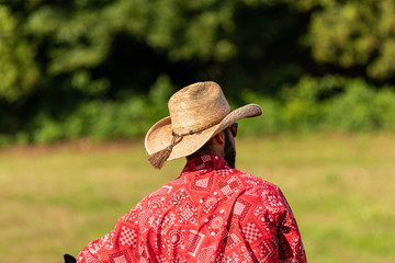 Cool Cowboy, warming up at Italian Rodeo show. Red shirt, blue jeans, leather boots, and heavy rope.