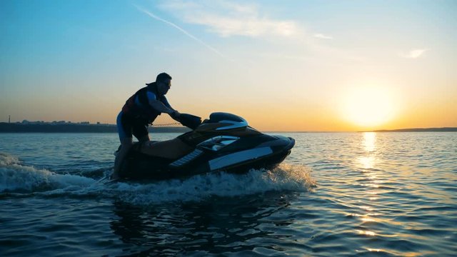 A man driving on a jet ski on water, close up.