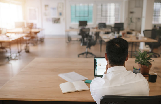 Businessman Working Alone In A Large Modern Office