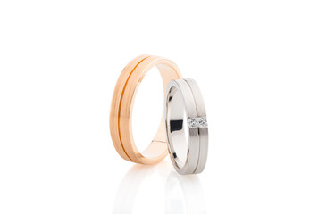 Pair of pink gold and white gold wedding rings with matte surface isolated on white background