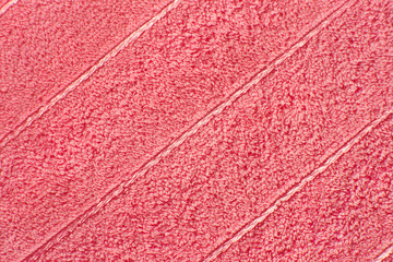Fototapeta na wymiar Texture of terry cloth. Background of fabric for sewing bath towels. Texture of soft tissue for bath towels in pink color.