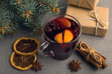 Mulled wine, a gift and spices on the table next to the tree. The concept of Christmas and New...
