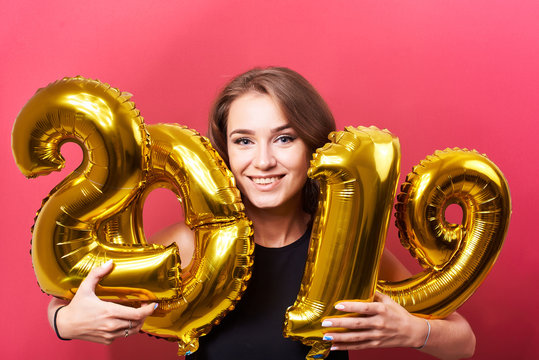 Young woman holding 2019 balloons in hands