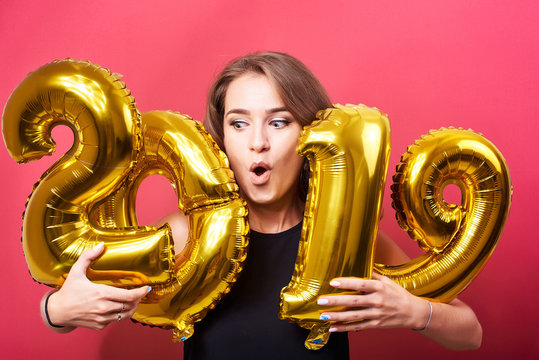 Young woman holding 2019 balloons in hands