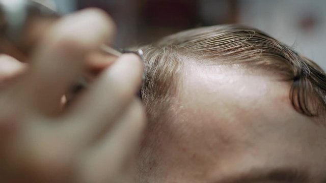 Barber trimming man hair in haircutter shop. Hair is a man. The man in the barber shop. Barbershop with master