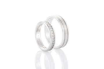 Pair of silver wedding rings with diamonds isolated on white background