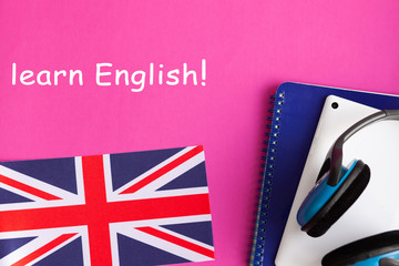 Learn English - British flag, headphones, tablet and notebook on a bright background