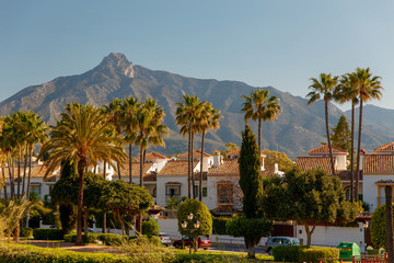 Marbella, Spain - May 4, 2018: Luxury property, beachside apartments  with beautiful blue skies, palm trees with gardens and sea and beach views. Holiday property in Spain on the Costa del sol. - obrazy, fototapety, plakaty