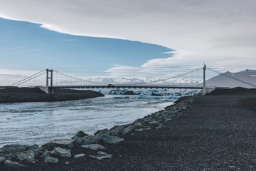 modern bridge crossing blue river with glacier water in Jokulsarlon, Iceland