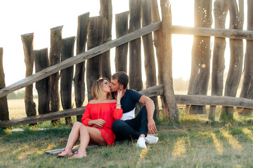Young beautiful enamored couple walking outdoors in summer at sunset