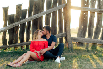 Young beautiful enamored couple walking outdoors in summer at sunset