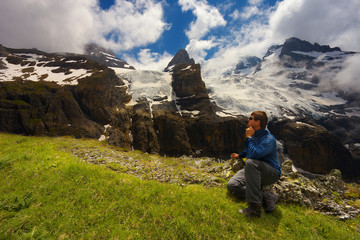 Fototapeta premium Tourist watching a mountain landscape with glaciers and peaks nearby resort of Kandersteg, Switzerland