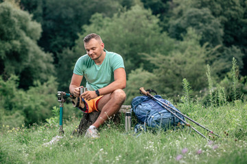 Delighted male tourist with prosthesis resting outdoors