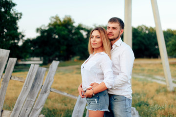 Fototapeta premium Young beautiful enamored couple walking outdoors in summer at sunset