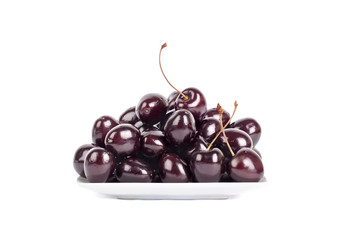 Cherries on a white background in a plate isolated close up