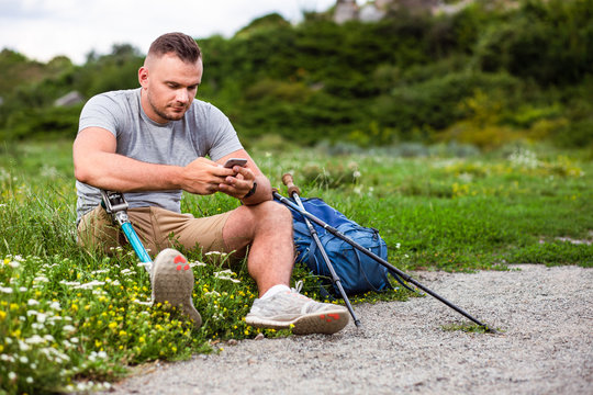 PLeasant man with prosthesis using his smartphone