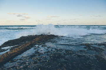 waves crashing over rocks, stormy sea, dramatic ocean, 