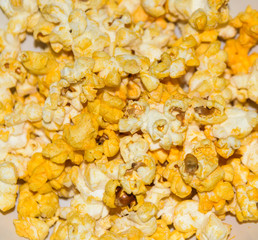 Salted popcorn grains with cheese. Selective focus with shallow depth of field.