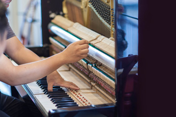 Piano repairers or musicians are repairing and customizing the piano.