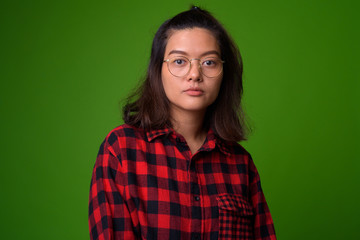 Fototapeta premium Young beautiful Asian hipster woman wearing eyeglasses and red checkered shirt
