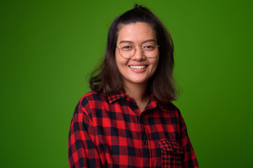 Fototapeta premium Young beautiful Asian hipster woman wearing eyeglasses and red checkered shirt