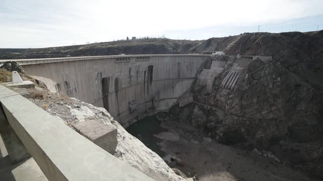 Semi circular concrete support of Agua de Toro Dam. Detail of huge hydroelectric structure and dry river valley as consecuence. San Rafael, Argentina