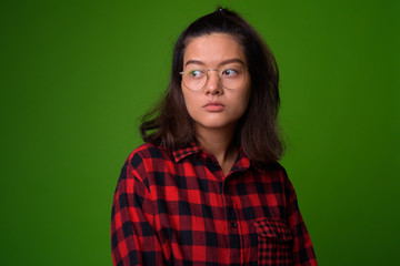 Fototapeta premium Young beautiful Asian hipster woman wearing eyeglasses and red checkered shirt