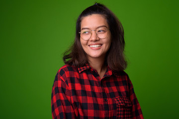 Young beautiful Asian hipster woman wearing eyeglasses and red checkered shirt