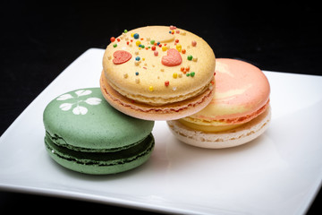Homemade assorted macarons beautifully decorated with colorful hearts, green tea and yellow and gold color