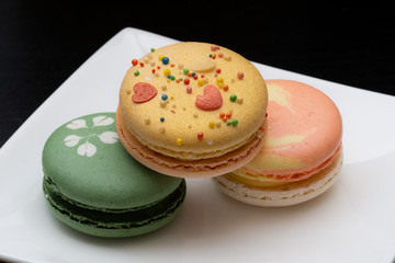 Homemade assorted macarons beautifully decorated with colorful hearts, green tea and yellow and gold color