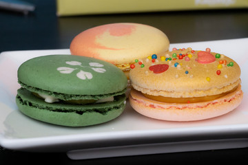 Homemade assorted macarons beautifully decorated with colorful hearts, green tea and yellow and gold color