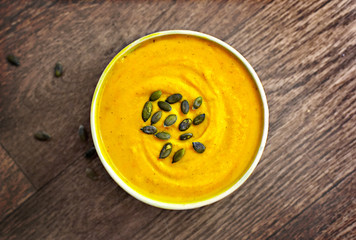 Hokkaido or butternut pumpkin soup with curry and seeds. Delicious autumn dish, top view.