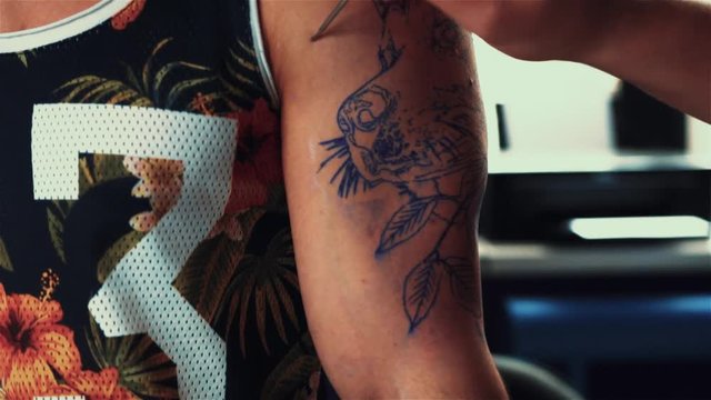 Slider Shot Of Tattooist Doing Tattoo on Male Shoulder. Tattoo Master at Work.