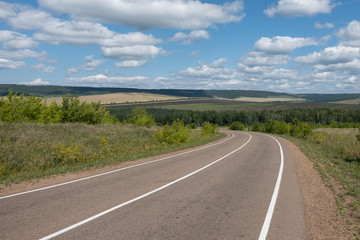An asphalt road with white markings stretching into the distance.