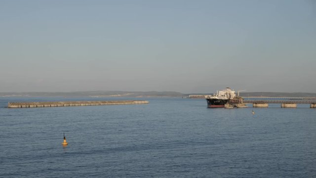LNG tanker loading alongside jetty in port