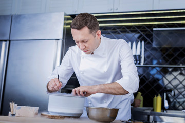 Much work. Busy pleasant cook beling calm while preparing a dish for the guests