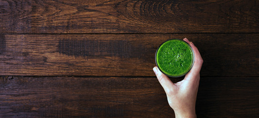 Smoothies, green drink in hand, diet food, wooden background, copy space, long banner