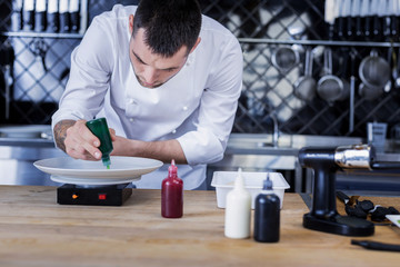 Process. Young ambitious cook preparing all the ingredients while being in the kitchen